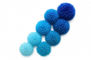 Blue yarn pompoms in gradating shades, positioned diagonally across transparent surface, displaying soft color progression