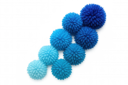 Blue yarn pompoms in gradating shades, positioned diagonally across transparent surface, displaying soft color progression