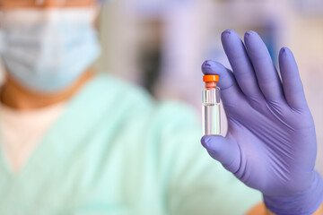Male doctor with ampoule in clinic, closeup