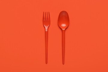 Fork with spoon on orange background