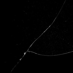 Vidrio roto con grietas brillantes sobre fondo negro, alto contraste que resalta la textura y crea un efecto impactante y elegante. © Mylifeontopdm