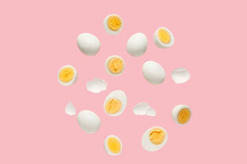 Flying boiled chicken eggs with shells on pink background