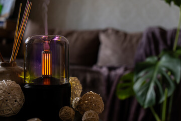 Close up of home perfume scent air humidifier with light. Aromatherapy holistic health practices concept. Stress relief activities preparing for meditation. Simple pleasures healing habits