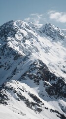 Naklejka premium Snow-covered mountain peaks under clear blue sky with rugged rocky terrain and pristine alpine landscape in winter season
