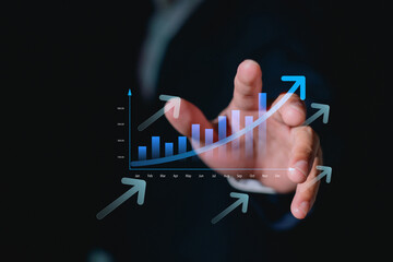 Business growth concept with hand pointing at rising bar chart and upward arrows, symbolizing success, financial profit, strategy positive economic performance.