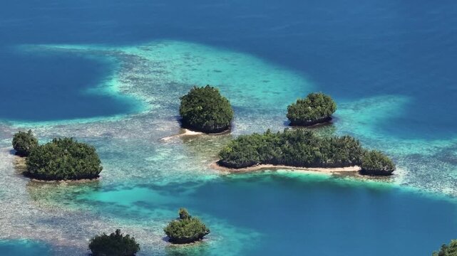 Cluster of tropical islets with turquoise ocean water and corals. Britania Islands. Surigao del Sur, Philippines. Zoom view.