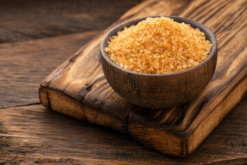 Saccharum officinarum - Organic brown sugar in a wooden bowl