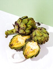 Fototapeta premium Fresh artichokes, halved and whole