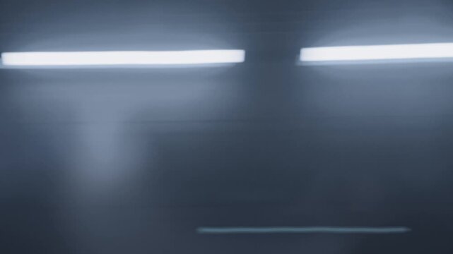 Side view of train passing by at high speed. The subway is moving forward, and the motion blur effect is.