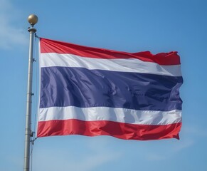 Vibrant Thailand flag waving proudly in the bright blue sky represents freedom and national pride