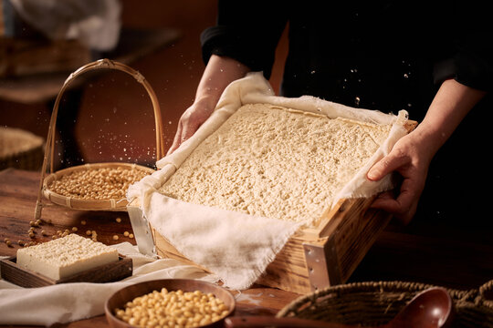 The Artisanal Process of Creating Tofu and Soy Milk by Hand,Grinding Soaked Soybeans with Stone Mill for Fresh Soy Milk