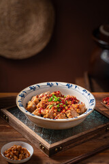 Braised pork ribs and chili peppers, old vintage kitchen interior wooden tabletop background