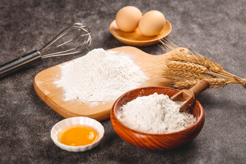 Fresh wheat flour, eggs and baking ingredients with wooden utensils for homemade bread making