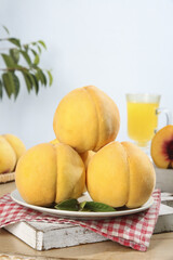 Freshly picked yellow peaches on plate with juice in rustic kitchen setting