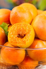 Fresh Ripe Apricots in Glass Bowl with Cut Half Showing Orange Flesh and Pit