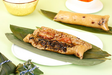 Traditional Asian Rice Dumplings Wrapped in Bamboo Leaves on White Plates