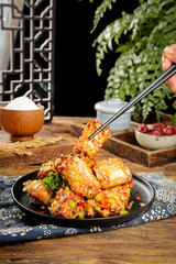 Fresh Fried Pork Ribs with Garlic - Traditional Asian Cuisine on Black Plate with Chopsticks