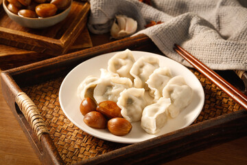 Asian Steamed Dumplings with Garlic Sauce and Chestnuts on Wooden Table