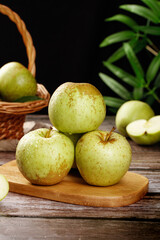 Freshly Picked Green Apples from Shandong on Wooden Board with Wicker Basket