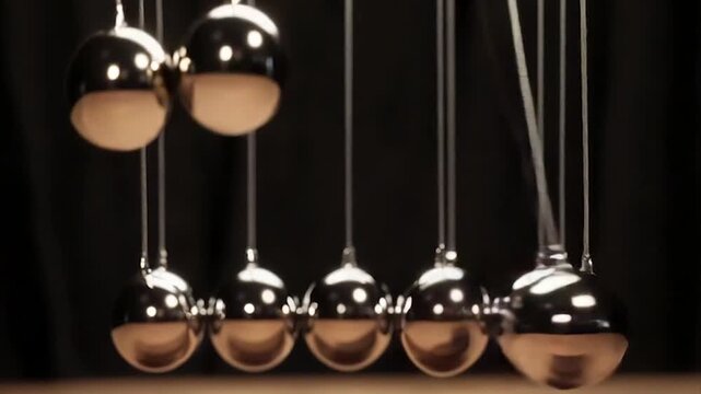 Polished metal balls hanging on strings, a Newtonian physics demonstration