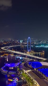 night illumination singapore city marina bay famous hotel mall aerial vertical panorama 4k timelapse
