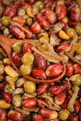 Fried peanuts with spices and beans on wooden spoon - traditional Asian snack mix