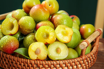 Fresh Cut Plums with Yellow Pulp Displayed in Wicker Basket on Wood Surface