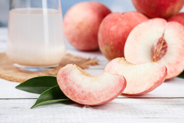 Fresh Red Peaches Sliced on White Wood Table with Milk Glass