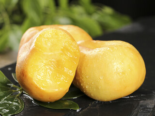 Fresh Golden Nectarine Cut in Half with Water Droplets on Dark Slate