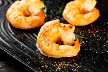 Large Fresh Shrimp Seared Golden Brown on Black Grill Pan with Herbs and Spices