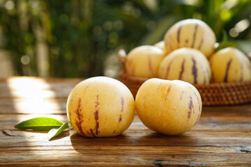 Fresh Pepino Melons with Purple Stripes on Rustic Wooden Table - Sweet Colorful Fruit Display