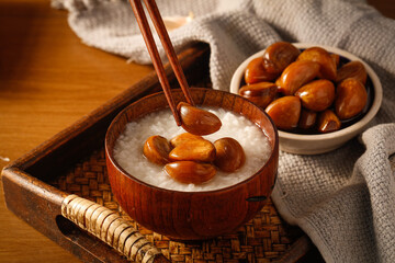 Fresh Dates in Wooden Bowl with Rice Porridge Base - Traditional Healthy Breakfast Dish on Rustic Tray
