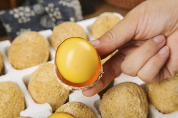 Hand holding cracked egg with golden yolk closeup display of fresh farm eggs