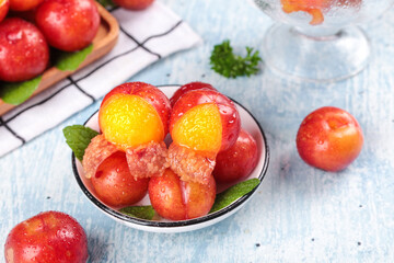 Fresh Red Plums with Water Drops in Bowl on Wooden Background - Healthy Summer Stone Fruit Display