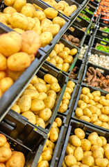 supermarket shelfs with fresh vegetables, potatoes, okra, sweet potato, garlic, tomatoes, green, yellow, red