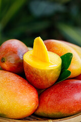 Fresh Ripe Mango Fruit with Orange Yellow Flesh and Green Leaf in Wicker Basket