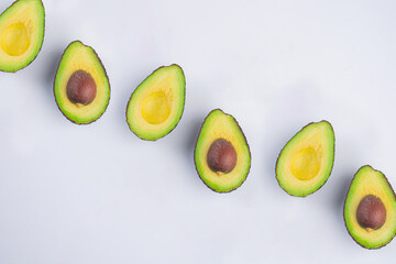 Whole and half avocado isolated on white background close-up.