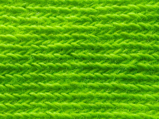 Vibrant green knitted fabric with a detailed horizontal ribbed texture, showing a seamless and uniform pattern in a close-up macro view.