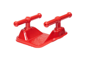 Small red plastic childrens snow sled with handles isolated.