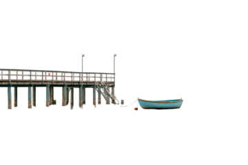 A solitary turquoise boat rests beside a long wooden pier.