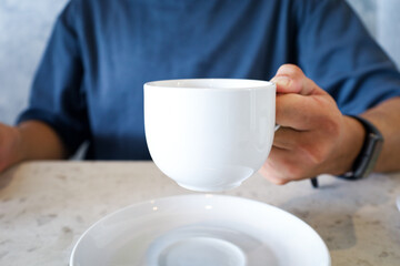 Simple White Cup with Coffee Being Held At Casual Restaurant