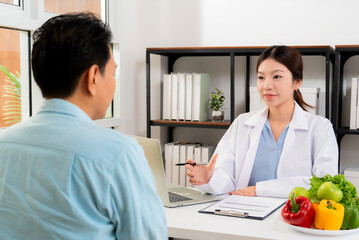 Fototapeta premium Asian nutritionist consulting patient in clinic, meal plan discussion, healthcare advice, weight loss support, doctor talking and explaining patient for nutrition consultation, wellness care.