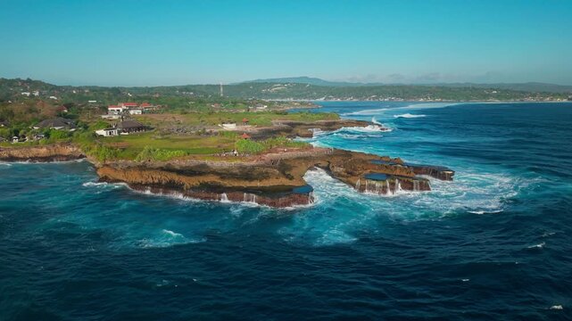 Drone video of big waves crashing at Devils Tears, dream beach a popular tourist spot on Nusa Lembongan island near Bali in Indonesia. 