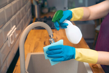 Using cleaning products for cleaning table in kitchen at home. Housekeeping, household chores.