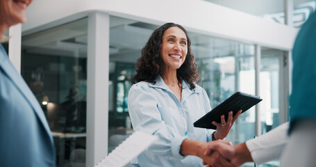 Handshake, doctor and woman in hospital, tablet and welcome with smile, thank you and hello. Mature person, healthcare and happy employees in workplace, shaking hands and tech with onboarding or app © peopleimages.com