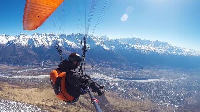 Experience breathtaking aerial views during a paragliding adventure over snow capped mountains
