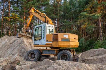Wheeled excavator doing earthworks to prepare land for construction projects