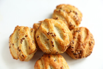 Mini pies with sesame seeds on white background