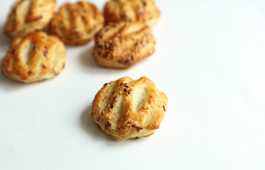 Mini pies with sesame seeds on white background