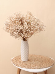 Minimalist modern vase with dry grass on a table. Boho style